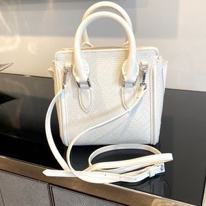 White Alexander McQueen bag which can be worn using handles  or crossbody strap.